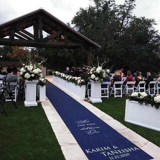 Personalized printed blue fabric aisle runner at outdoor wedding