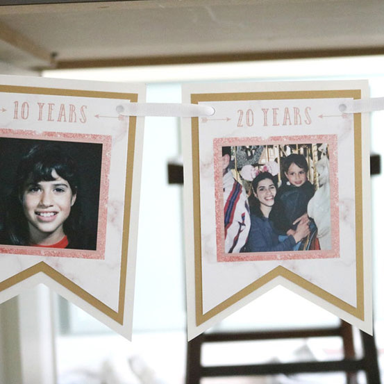 close up of pink garland banner with photographs showing the birthday girl at 10 years and 20 years