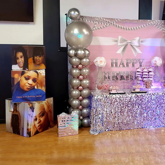 3 giant photo cubes stacked on top of each other alongside a birthday dessert table