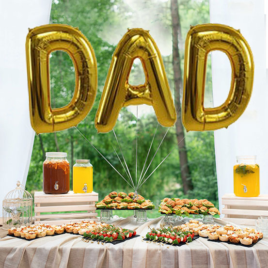 Giant gold letter balloons spelling the word DAD above a buffet table