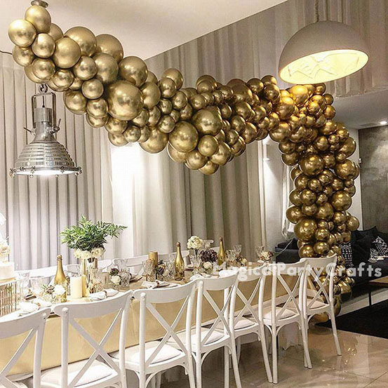 gold balloon garland hung above a long dinning table