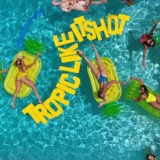 Tropic Like Its Hot yellow pool float letters at a pool party