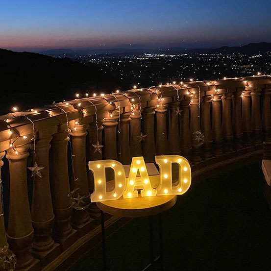 small marquee letters spelling Dad on terrace at night