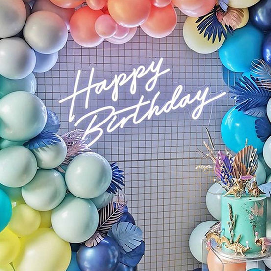 happy birthday neon sign surrounded by balloons