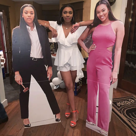 woman standing next to a life size cutout of herself