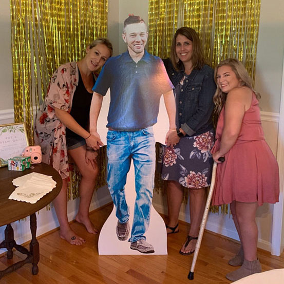 man standing next to a life size cutout of himself at a 21st birthday party