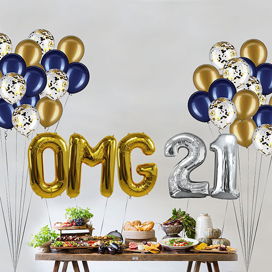 Giant gold and silver letter balloons spelling the phrase OMG 21 above a buffet table