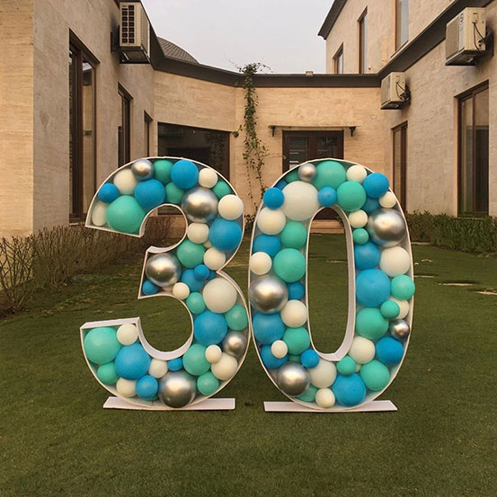 30 balloon mosaic numbers filled with black balloons inside a house