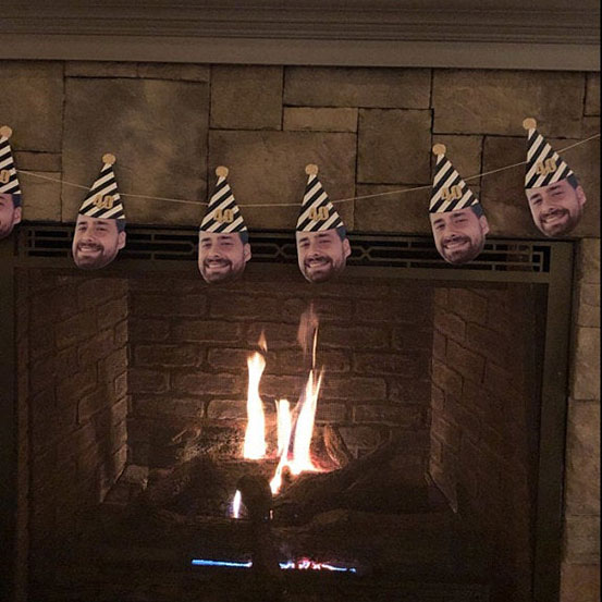 custom face banner of man in 40 party hat hung above fireplace