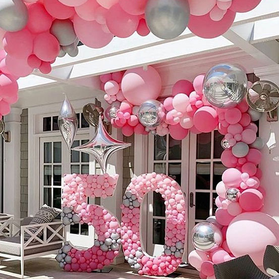 50 balloon mosaic numbers filled with black balloons inside a house