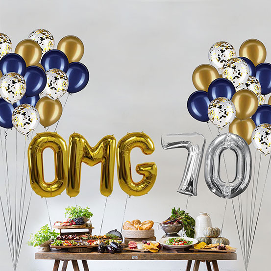 Giant gold and silver letter balloons spelling the phrase OMG 70 above a buffet table