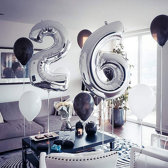 Giant number 26 balloons next to flowers