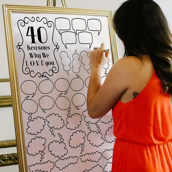 Woman writing on a 40 Reasons We Love You poster