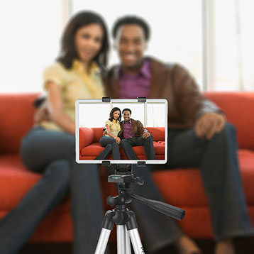 couple toasting drinks and recording a video message on a tablet