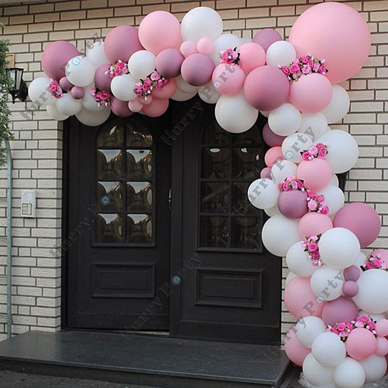 Pink and white balloon garland surrounding the entrance to a house