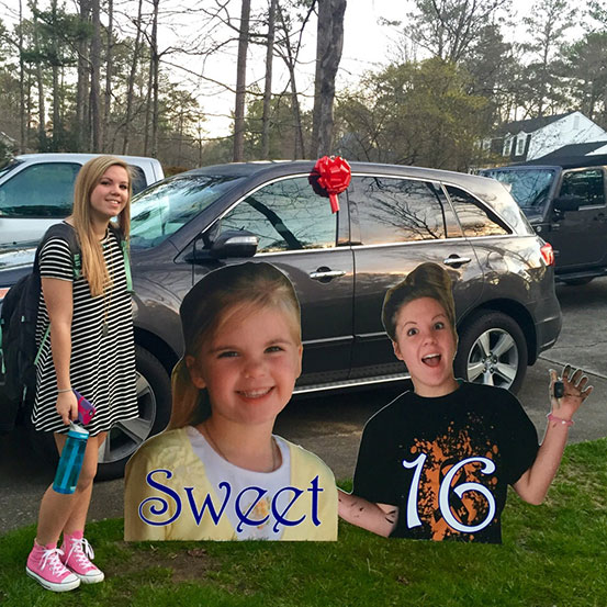 girl standing next to half body cut outs of herself at different ages in front yard for Sweet 16 party
