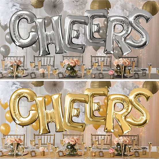 Giant gold and silver letter balloons spelling the word CHEERS above a party dining table