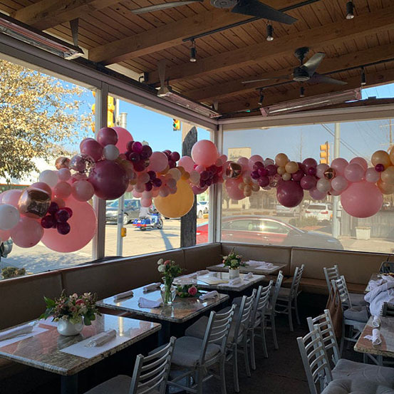 balloon garland draped around the windows inside a restaurant
