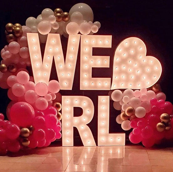 Large marquee letters spelling WE HEART RL surrounded by balloons