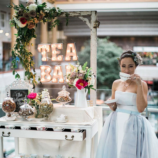 light up marquee sign spelling TEA BAR at wedding with bride sipping tea