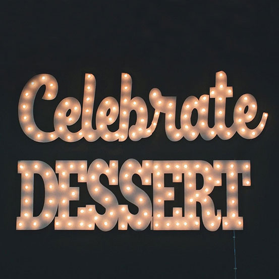 light up marquee sign spelling CELEBRATE and DESSERT