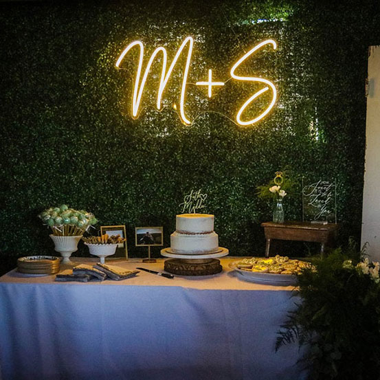 M+S custom initials neon sign above dessert table at wedding