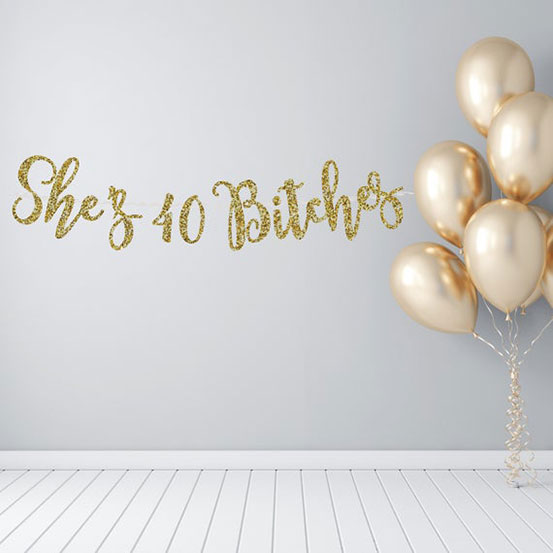 She's 40 Bitches gold text banner hung on wall