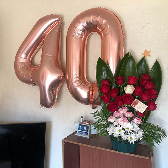 Giant rose gold number 40 balloons next to flowers