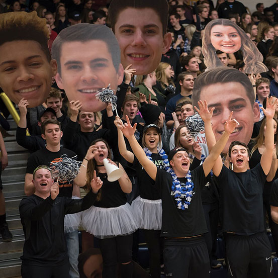 group of young people holding big head cutouts