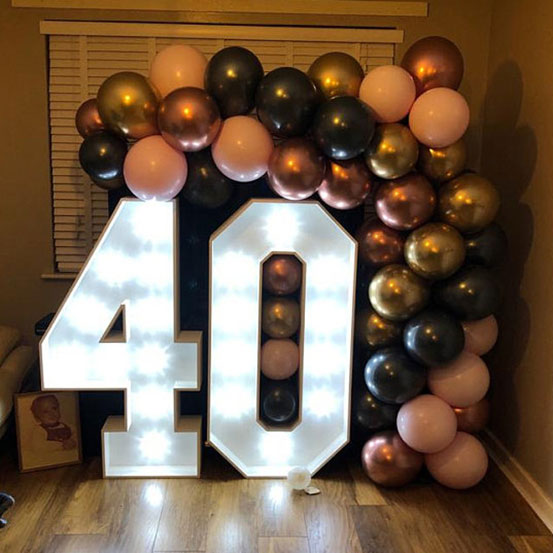 Large marquee letters spelling 40 surrounded by balloons