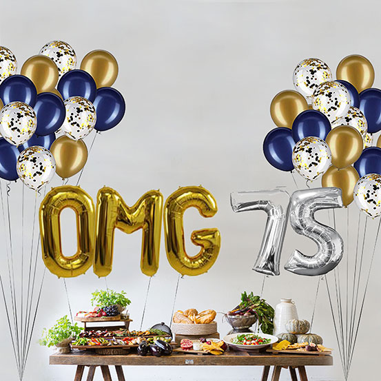 Giant gold and silver letter balloons spelling the phrase OMG 75 above a buffet table