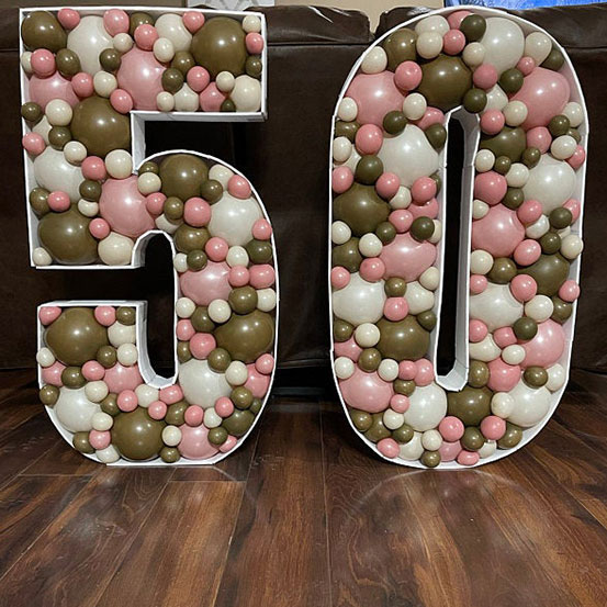 75 balloon mosaic numbers filled with black balloons inside a house