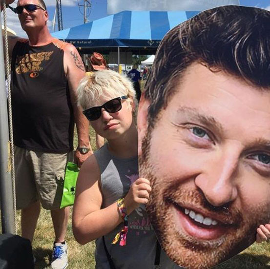 man holding big head cutout in front of his face