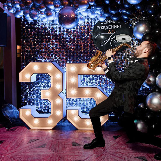 Large marquee letters spelling 75 surrounded by balloons