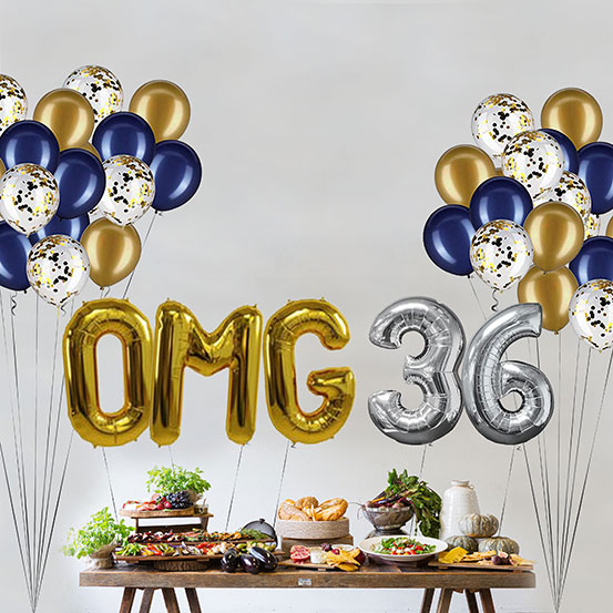 Giant gold and silver letter balloons spelling the phrase OMG 36 above a buffet table