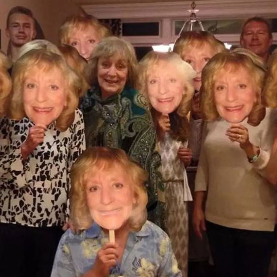 group of women holding up custom fan faces of a friend's face